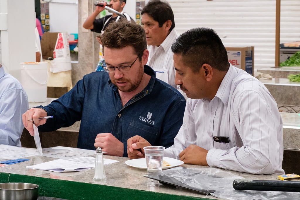Trent Blare (left), economist at CIMMYT and leader of the study, conducts a choice experiment with interviewee Luis Alcantara. (Photo: Carolyn Cowan/CIMMYT)