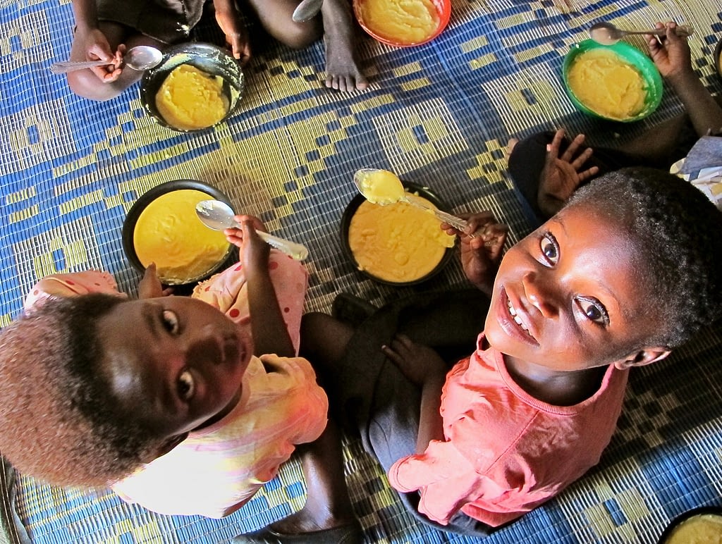 Two girls eat biofortified maize in Mukushi, Zambia. (Photo: Silke Seco/DFID)