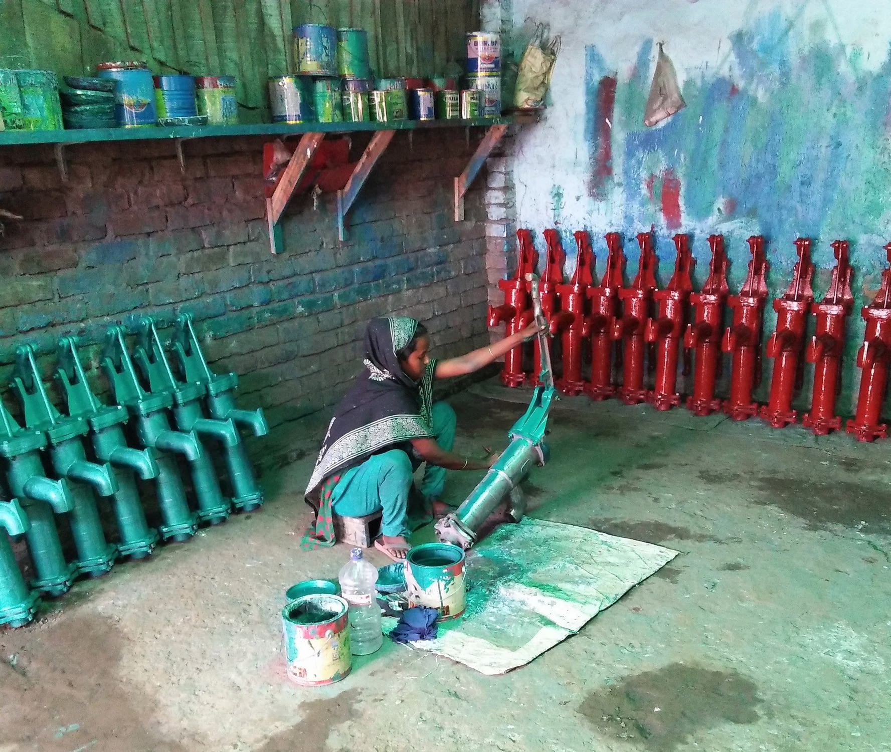Woman paints machinery.