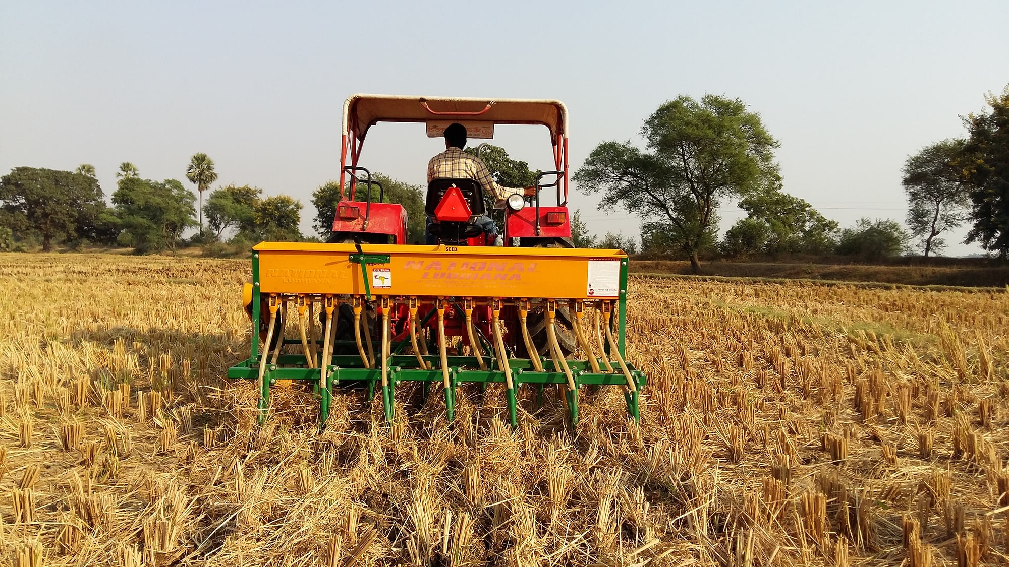 A farmer in India uses a tractor fitted with a Happy Seeder. (Photo: Dakshinamurthy Vedachalam/CIMMYT)