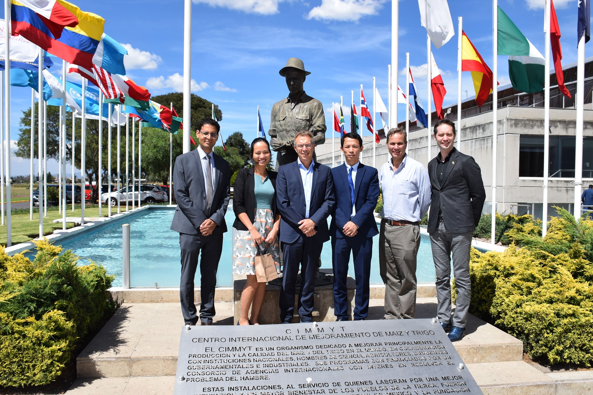 Visitors from the Embassy of Vietnam in Mexico and members of CIMMYT senior management stand for a group photograph next to the Norman Borlaug statue at CIMMYT's global headquarters. (Photo: Jose Luis Olin Martinez for CIMMYT)