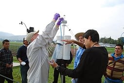 Frieder Hofmann demonstrates how to rinse the pollen from a trap, with Seed Health Laboratory research assistant, Benjamin Asael Martínez, holding the collection bottle.